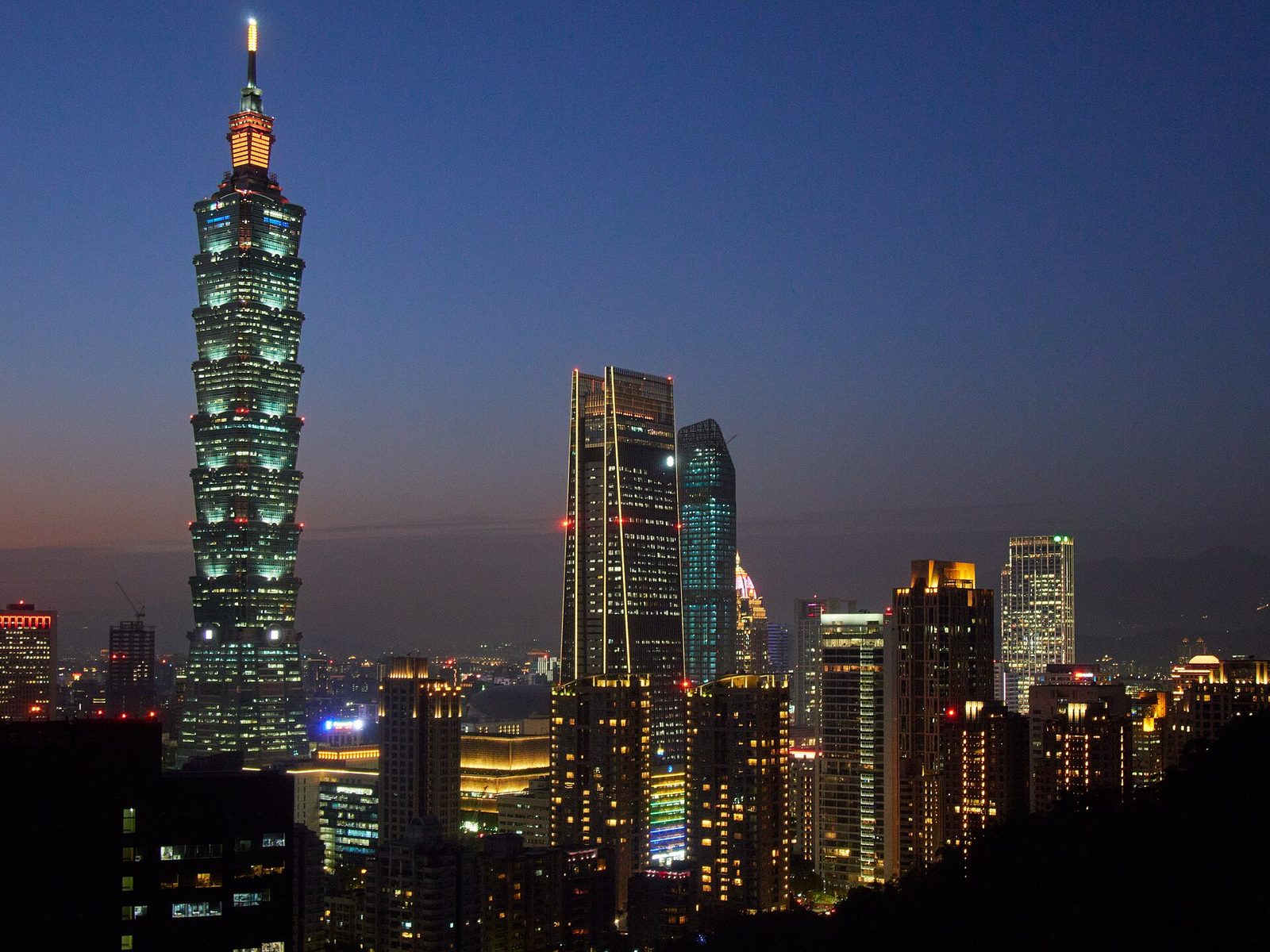 Night-time Taipei skyline with Taipei 101 rising above the office towers of the Xinyi District